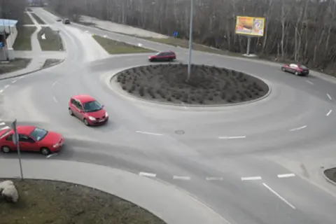 Rondo turbinowe jak jeździć: czerwone samochody płynnie poruszają się po rondzie, pokazując zasady ruchu.
