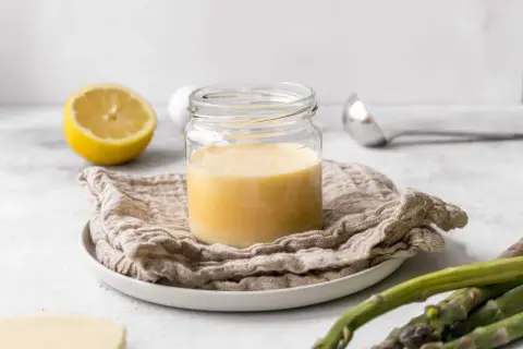 Cremige Sauce Hollandaise im Glas, zubereitet mit dem Thermomix. Dazu Zitrone und Spargel.