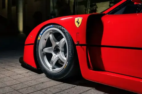 En röd fransk sportbil, en ikonisk Ferrari F40, med sitt legendariska häst-emblem och Michelin-däck.