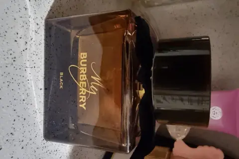Elegancka butelka perfum My Burberry Black z czarną wstążką i złotym napisem.