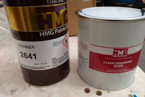 Deux boîtes de peinture HMG, l'une de diluant, l'autre de dope rétractable.