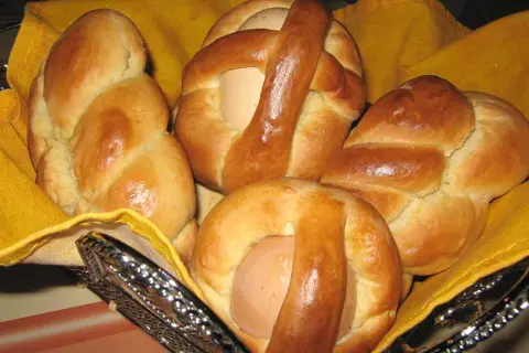 Cuzzupe calabresi morbide, dolci pasquali con uova, in un cestino foderato di giallo.