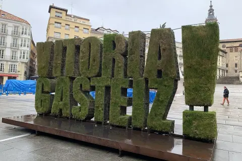 Letras gigantes cubiertas de césped con "VITORIA-GASTEIZ" en una plaza. ¡Un lugar genial que ver en Vitoria!