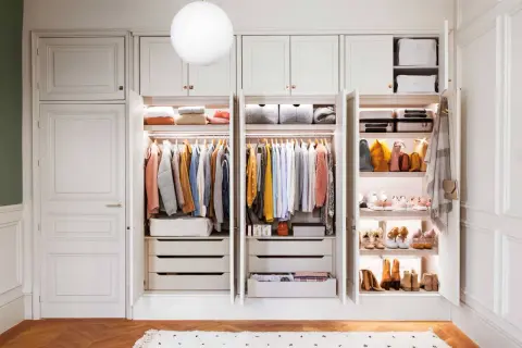 Un armario organizado es un sueño. Este proyecto armario muestra ropa colgada, cajones y estantes con bolsos y zapatos.