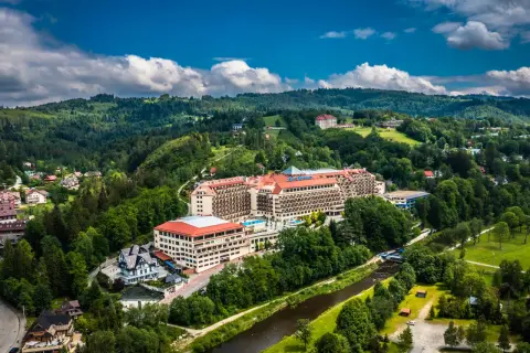 Gdzie są hotele Gołębiewski? Rozległy kompleks hotelowy w otoczeniu zielonych wzgórz i rzeki.