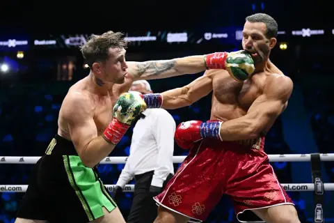 Två boxare i ringen, en träffar den andra i ansiktet. Intensiv action i en misfits boxing-match.
