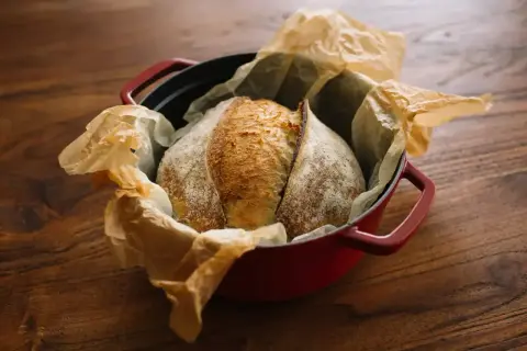 Chleb na zakwasie w czerwonym naczyniu żeliwnym, gotowy do pieczenia. Idealna temperatura pieca chleb to klucz do chrupiącej skórki.