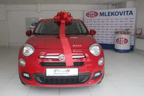 Czerwony Fiat 500X z wielką czerwoną kokardą, gotowy do wręczenia jako nagroda w loterii promocyjnej Vitay.