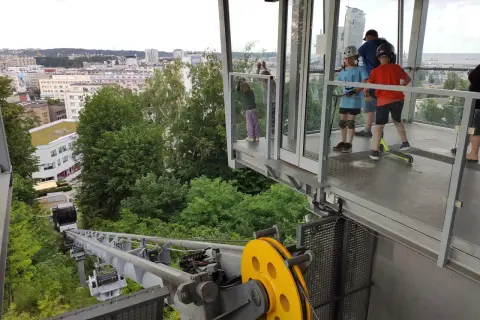 Dzieci z hulajnogami czekają na przejazd kolejką linową Gdynia. Widok na miasto i morze.