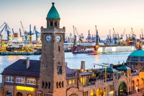 Hamburger Hafen bei Sonnenuntergang mit dem Altonaer Fischmarkt und vielen Kränen. Eine echte Attraktion Hamburgs.