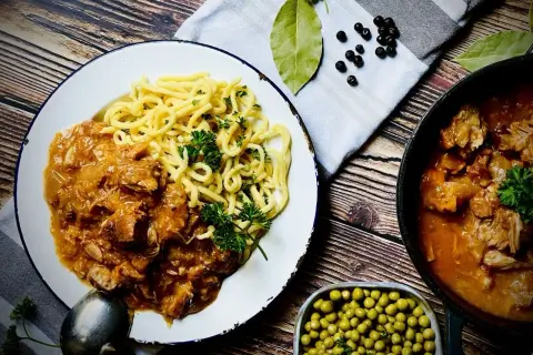 Herzhafter Biergulasch mit Spätzle, wie ihn Landfrauen lieben. Dazu Erbsen und Gewürze.