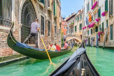 En gondoltur i Venedig är en dröm för många. Undrar du vad kostar det att åka gondol i Venedig? Här ser du en gondol som glider fram på kanalen.