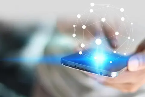 Dłoń trzyma smartfon, z którego emanuje sieć połączeń. Dowiedz się, jak zwiększyć zasięg LTE w telefonie.