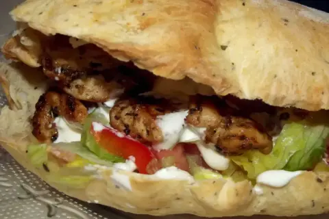 Pyszny kebab w picie z soczystym kurczakiem, świeżą sałatą, pomidorem i kremowym sosem. Idealny na szybki posiłek.