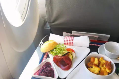 Smaczne posiłki flydubai: pieczone mięso, warzywa, sałatka, pieczywo i deser.