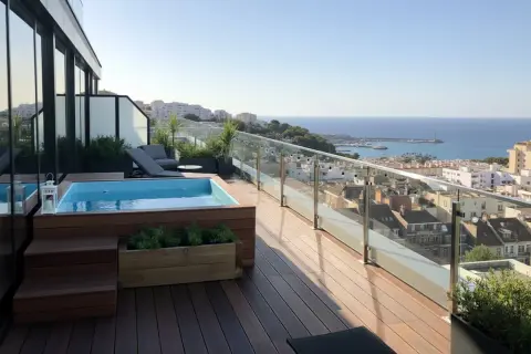 Relájate en las piscinas en áticos con vistas al mar. Terraza de madera, tumbonas y un jacuzzi privado.
