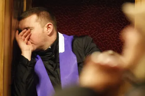 Mężczyzna w konfesjonale, z ręką na twarzy, zastanawia się, jakie są grzechy lekkie.