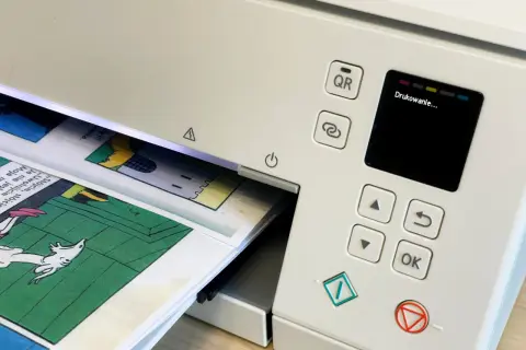 Drukarka drukuje komiks. Dowiedz się, jak wydrukować broszurę dwustronnie, by zaoszczędzić papier.