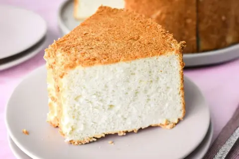 Una fetta soffice di angel cake, con la sua crosticina dorata, pronta per essere gustata.