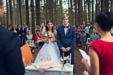 Para Młoda w lesie, goście czekają na ceremonię. Ile trwa ślub w kościele? To zależy, ale ta leśna przysięga jest wyjątkowa.