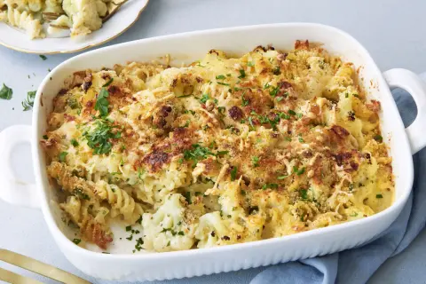 Ein goldbrauner Blumenkohl Auflauf mit Nudeln und knuspriger Käsekruste, garniert mit frischer Petersilie.
