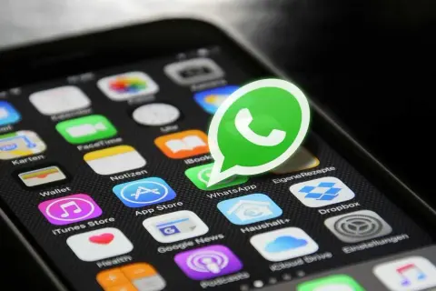 Widok ekranu telefonu z ikonami aplikacji, w tym dużą, zieloną ikoną WhatsApp. Osoba zablokowana na WhatsApp widzi brak możliwości kontaktu.