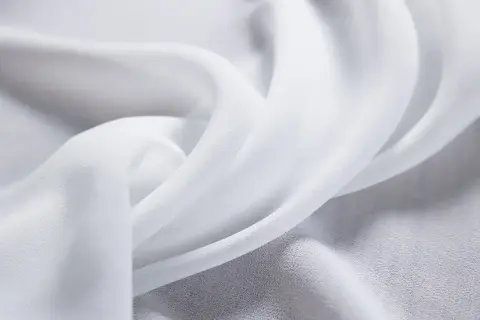 Delikatny, biały szyfon, co to za materiał? Lekki i zwiewny, idealny na letnie sukienki i eleganckie bluzki.