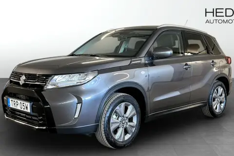 En mörkgrå Suzuki Vitara Hybrid står redo för en provkörning. Denna bil är perfekt för dig som söker en pålitlig och bränslesnål SUV.