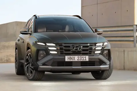Hyundai Tucson hybrid test. En mörkgrön SUV med distinkta LED-lampor och en modern grill.
