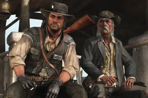 Dwóch kowbojów, jeden młodszy, drugi starszy, siedzi pod wiatą. Scena z gry Red Dead Redemption 2 PC.