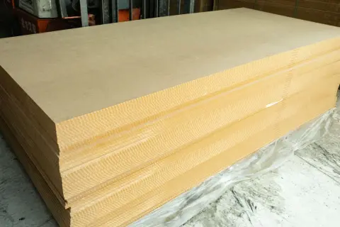 Pile de panneaux de contreplaqué ou aggloméré, prêts à être utilisés pour des projets de construction ou de décoration.
