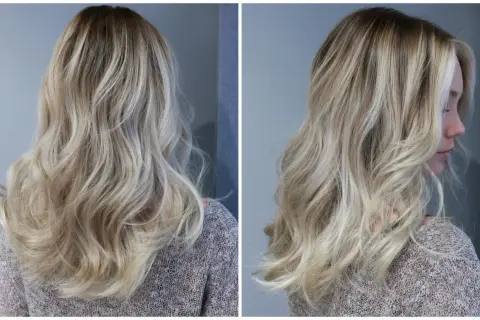 En kvinna med vackert, vågigt hår i en "old money blonde"-nyans. Håret har en naturlig, solkysst look med ljusa slingor.