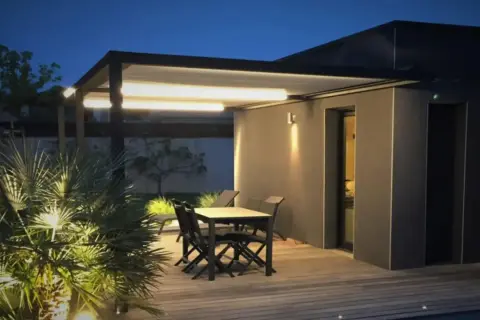 Iluminación moderna para tu pérgola: luces LED integradas y focos que realzan la vegetación.