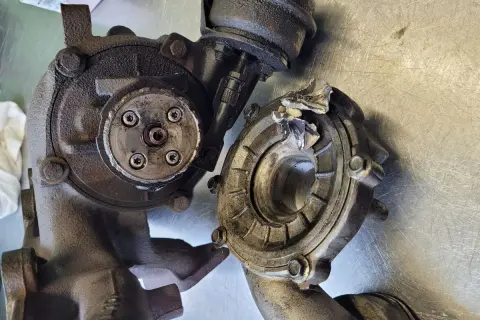 Uszkodzona turbosprężarka, prawdopodobnie z powodu awarii układu dolotowego. Widoczne fragmenty wirnika i obudowy.