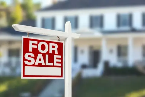 Cartello "For Sale" davanti a una casa. Si può vendere un immobile senza successione, una nuova opportunità per chi cerca casa.