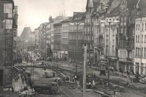 Prace budowlane na ulicy Święty Marcin w Poznaniu. Widać robotników, ciężki sprzęt i tory tramwajowe.