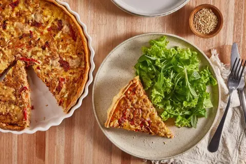 Tarta de atún dorada, servida con ensalada fresca. Un plato perfecto para disfrutar.