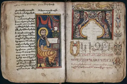 Ilustracja z Ewangelii św. Marka: święty siedzi przy biurku, pisząc. Obok ozdobne inicjały i miniatury.