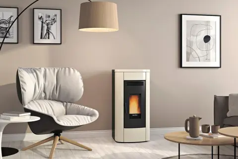 Gemütliches Wohnzimmer mit modernem Pellet-Kaminofen, dessen Flammen hinter Glas tanzen. Die schlichte tapete hinter kaminofen unterstreicht das Design.