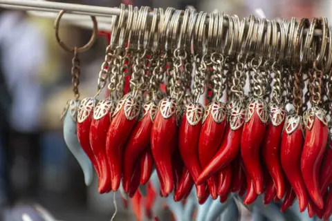 Portachiavi a forma di cornetti rossi, simbolo di "buona fortuna in napoletano", appesi a una catena.