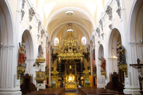 Interior de la iglesia san felipe zaragoza, con bancos de madera, un retablo dorado y estatuas de santos.