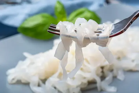 Makaron konjac na widelcu, gotowy do wypróbowania w nowych przepisach. Delikatne nitki, idealne do lekkich dań.