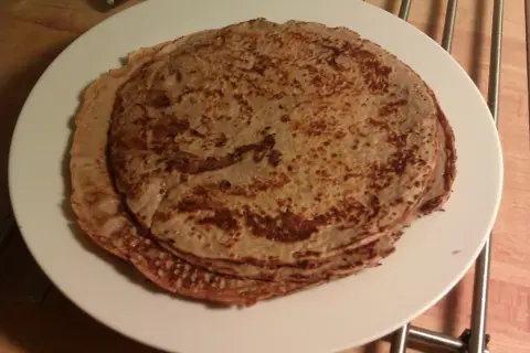 Stack of protein pancakes on a white plate.