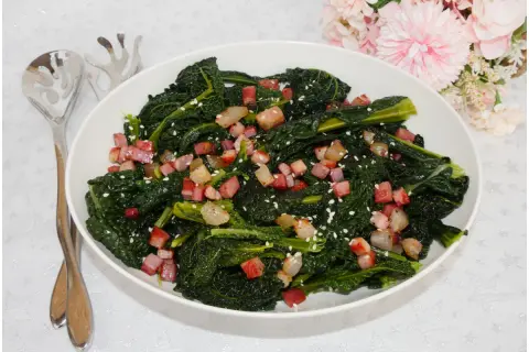 Cavolo nero in padella senza bollire, saltato con cubetti di pancetta croccante e semi di sesamo. Un contorno saporito e veloce.