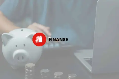 Skarbonka, monety i laptop sugerują zarządzanie finansami, w tym potencjalny podatek od darowizny.