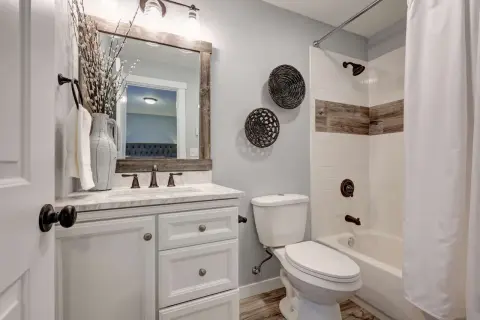 Ein **kleines Bad gestalten 4qm** mit weißem Waschtisch, Marmorplatte, Spiegel mit Holzrahmen und Dusche mit Holzakzenten.