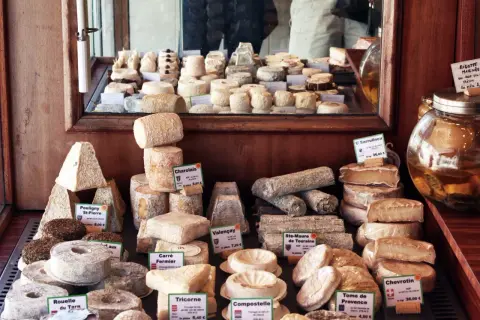 En ostdisk fylld med olika ostar, från pyramidformade till runda, med etiketter som "Charolais" och "Valençay". En stor burk med vätska står bredvid. En ost med namnet "parmesan gravid" skulle passa perfekt här.