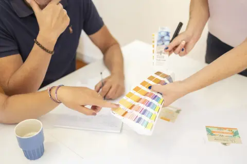 Des mains choisissent des couleurs sur un nuancier Pantone, lors d'une réunion de photo entreprises.