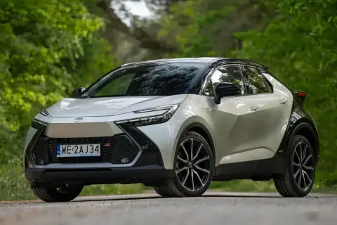 Nowy Toyota C-HR GR Sport w białym kolorze, zaparkowany na leśnej drodze. Zastanawiasz się nad jego **toyota chr spalanie**?