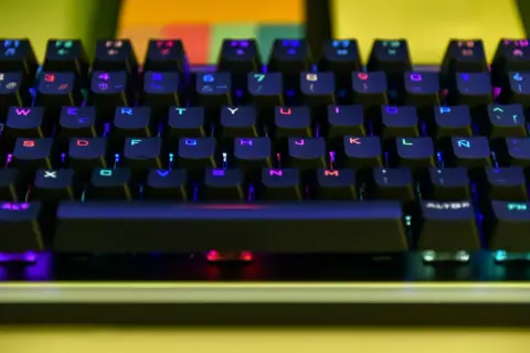 Klawiatura ważona z kolorowym podświetleniem RGB. Litery i cyfry na klawiszach świecą na niebiesko, czerwono i zielono.